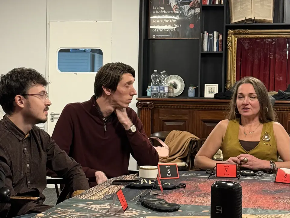 Three players at the table with game name cards